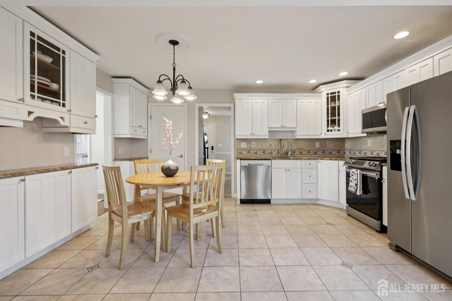 53 Salem Street Edison, NJ 08820 - Photo 11 of 39 a kitchen with stainless steel appliances granite countertop a stove a sink a refrigerator a microwave oven and white cabinets