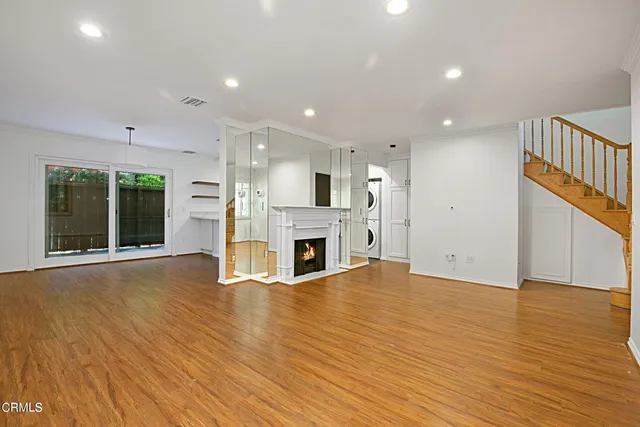 a view of a livingroom with fireplace wooden floor and window
