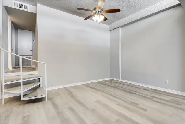 an empty room with a empty space and a ceiling fan