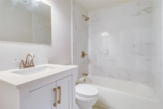 a bathroom with a sink toilet vanity and shower