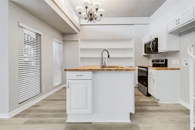 a kitchen with kitchen island a sink stainless steel appliances and cabinets