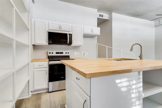 a kitchen with a sink a stove and microwave