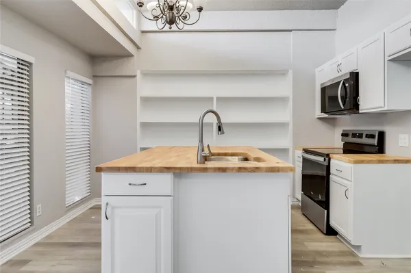 a kitchen with stainless steel appliances granite countertop a sink a stove and a microwave