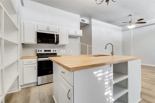 a kitchen with stainless steel appliances a stove microwave and sink