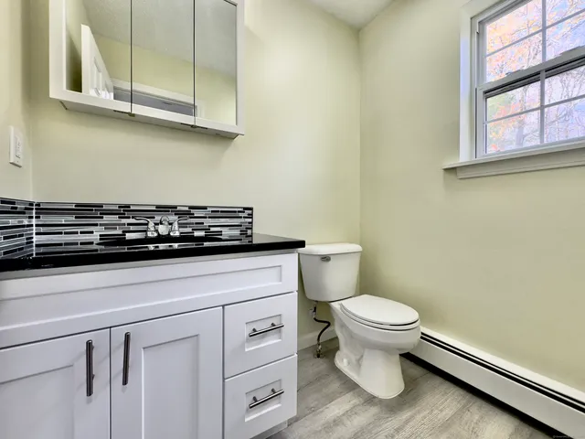 a bathroom with a toilet a sink and a window