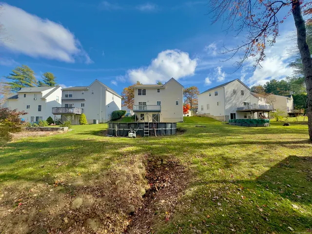 a view of a house with a big yard and large trees