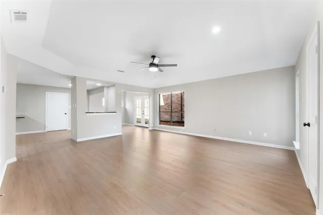 a view of a livingroom with wooden floor and a ceiling fan