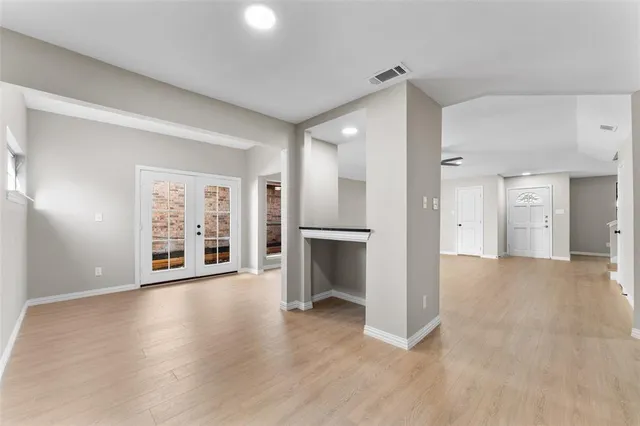 a view of a big room with wooden floor and a kitchen