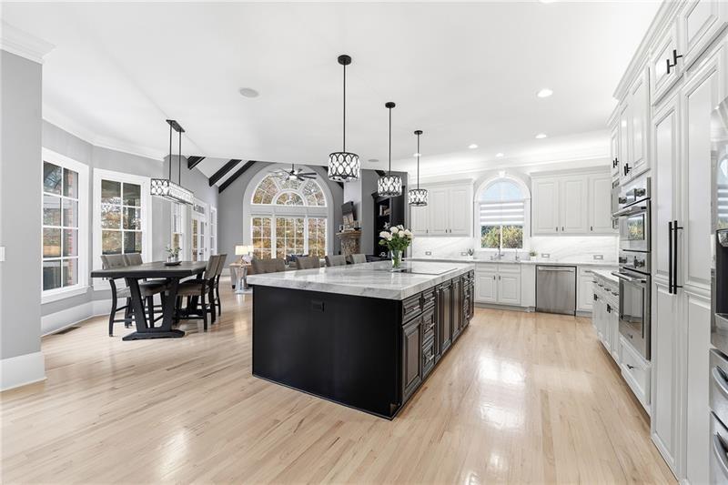170 Golf Link View Milton, GA 30004 - Photo 17 of 54 a kitchen with stainless steel appliances granite countertop a stove a sink dishwasher a refrigerator and a dining table with wooden floor