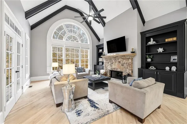 a living room with furniture a fireplace and a flat screen tv