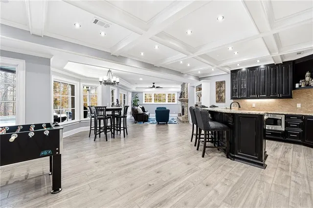 a open kitchen with lots of counter space a sink appliances and a dining table