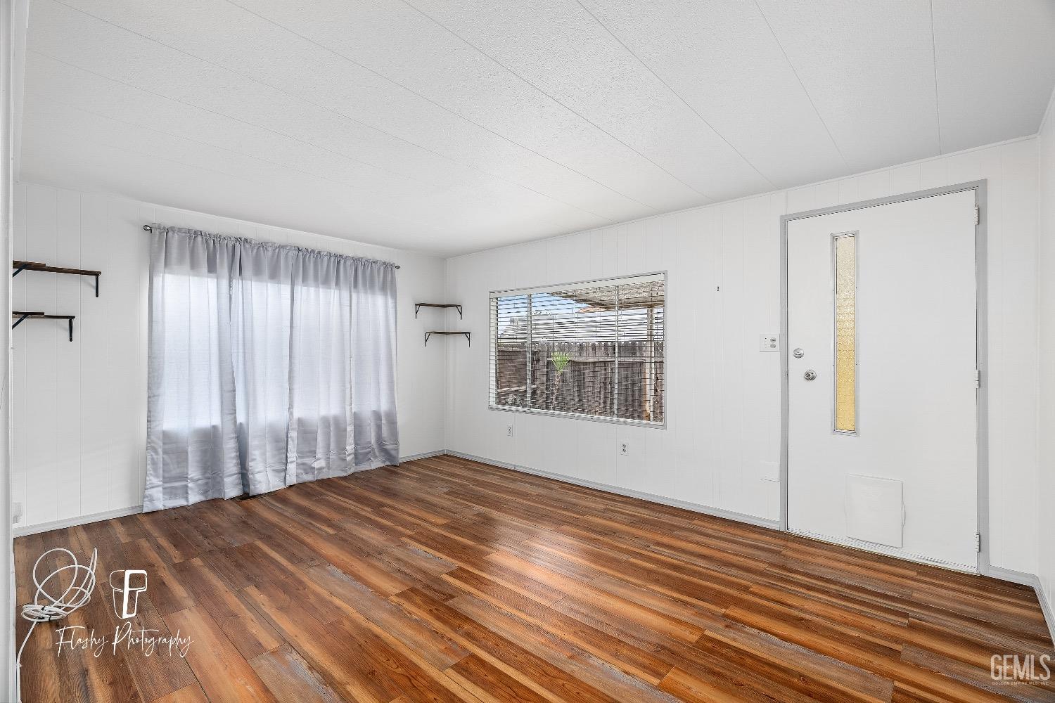 Undisclosed Address Bakersfield, CA 93301 - Photo 7 of 27 a view of empty room with wooden floor and fan