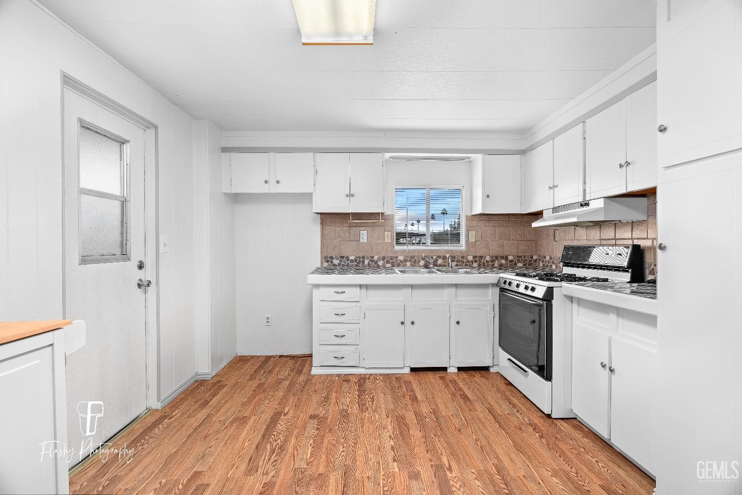 Undisclosed Address Bakersfield, CA 93301 - Photo 9 of 27 a kitchen with a sink window and cabinets