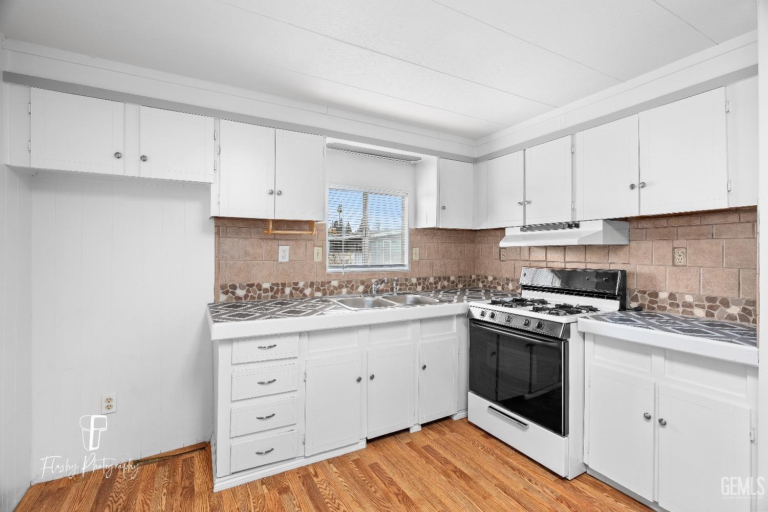 Undisclosed Address Bakersfield, CA 93301 - Photo 10 of 27 a kitchen with cabinets appliances a sink and a counter top space