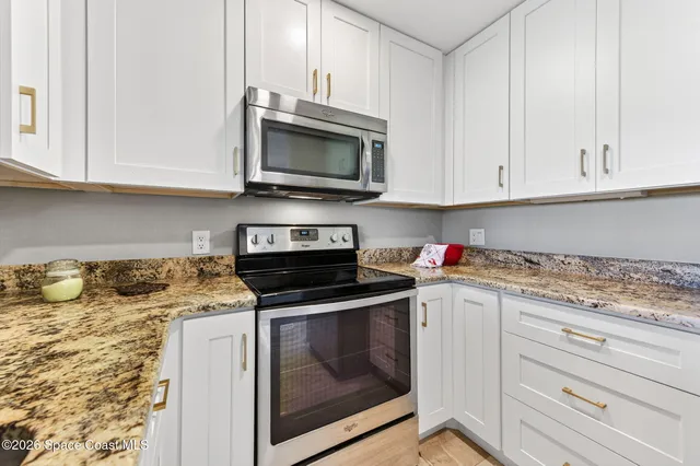 a en suite bathroom with a granite countertop sink and a mirror