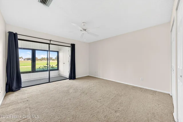 an empty room with fan and entrance