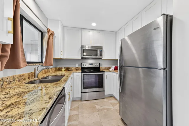 a kitchen with granite countertop a sink and a stove
