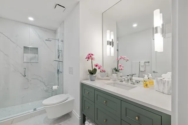 a bathroom with a sink a toilet and shower