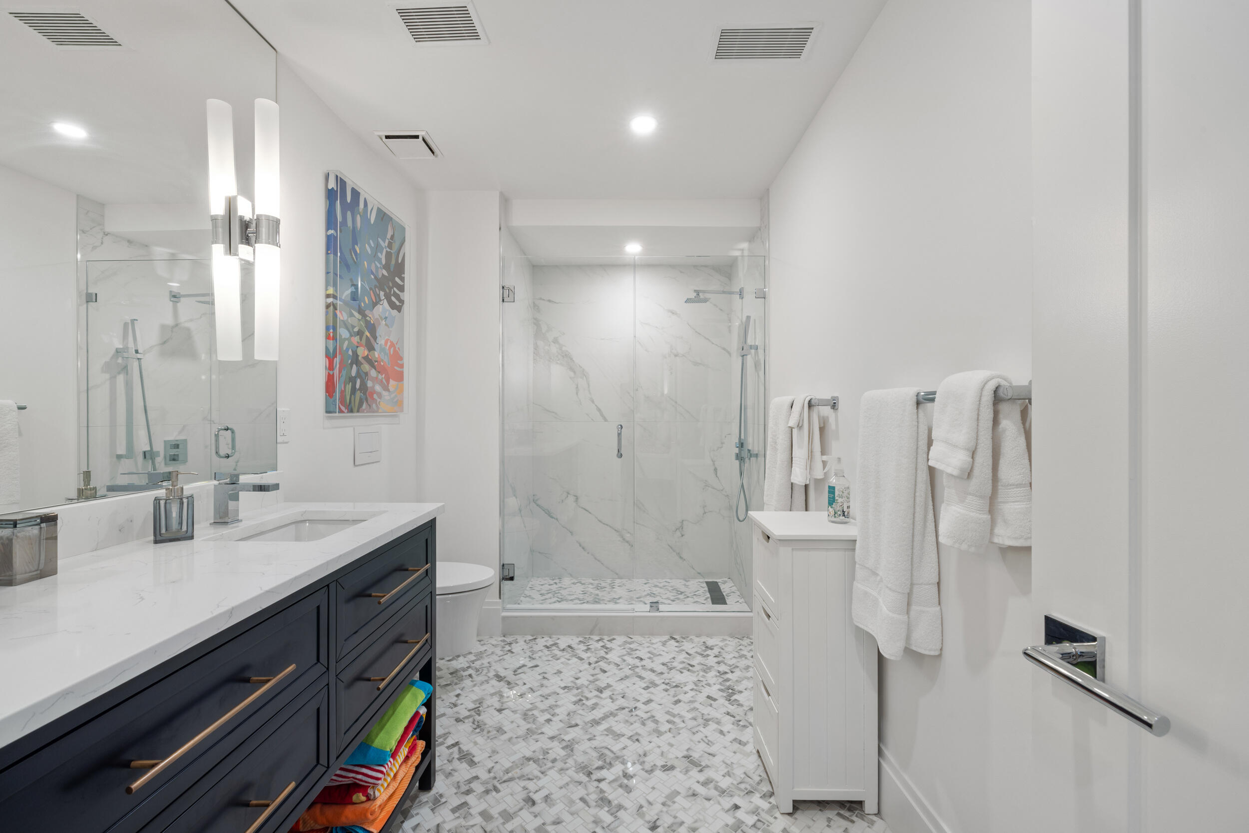 300 South Ocean Boulevard, Unit 3G Palm Beach, FL 33480 - Photo 17 of 25 a bathroom with a double vanity sink a toilet a mirror and shower