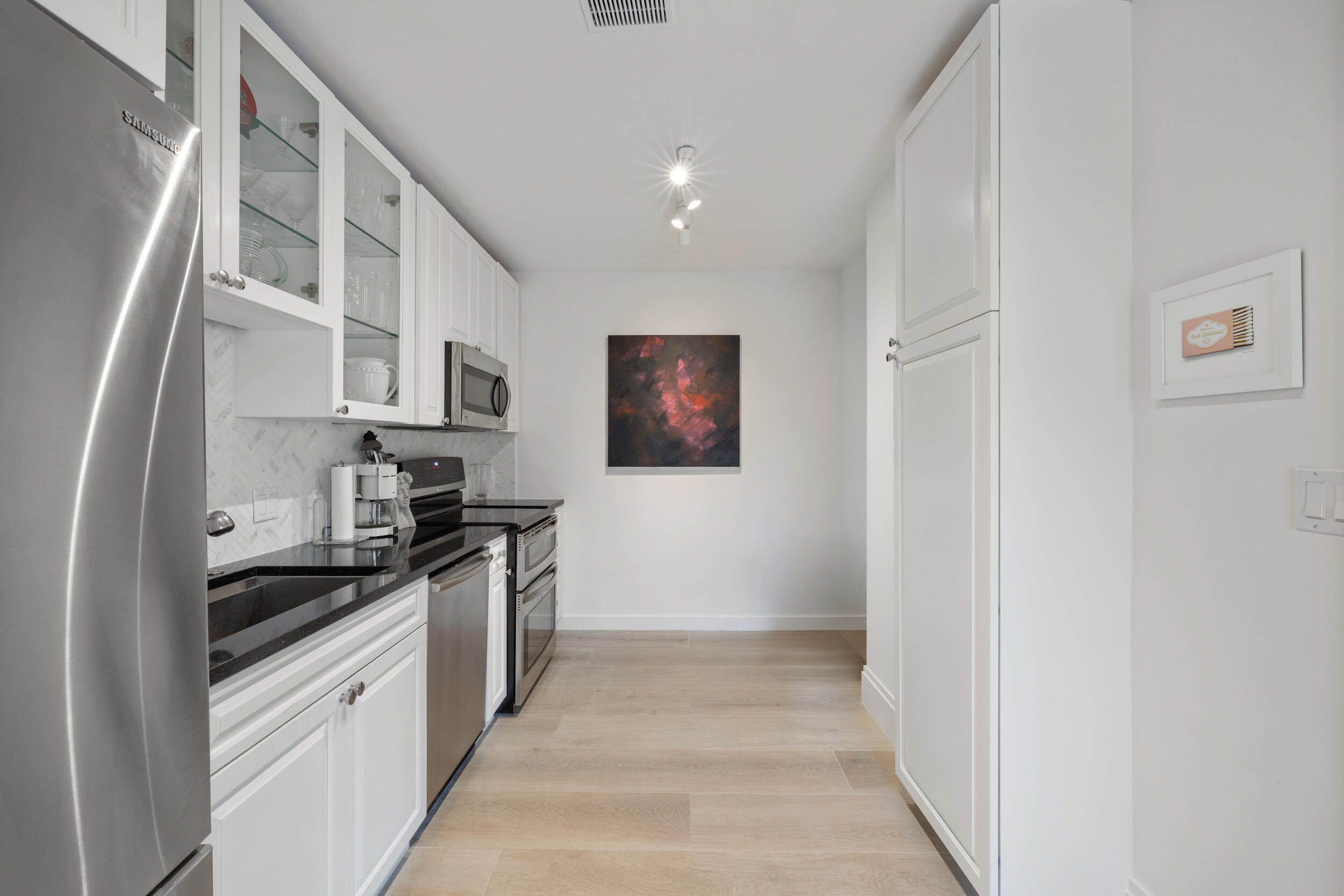 300 South Ocean Boulevard, Unit 3G Palm Beach, FL 33480 - Photo 8 of 25 a kitchen with stainless steel appliances a sink and a stove top oven