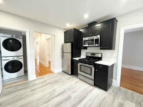 a kitchen with stainless steel appliances granite countertop a stove a refrigerator and a sink