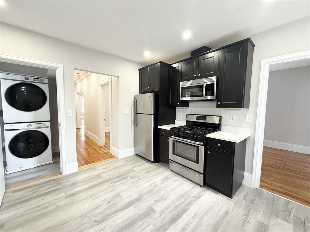 a kitchen with stainless steel appliances granite countertop a stove a refrigerator and a sink