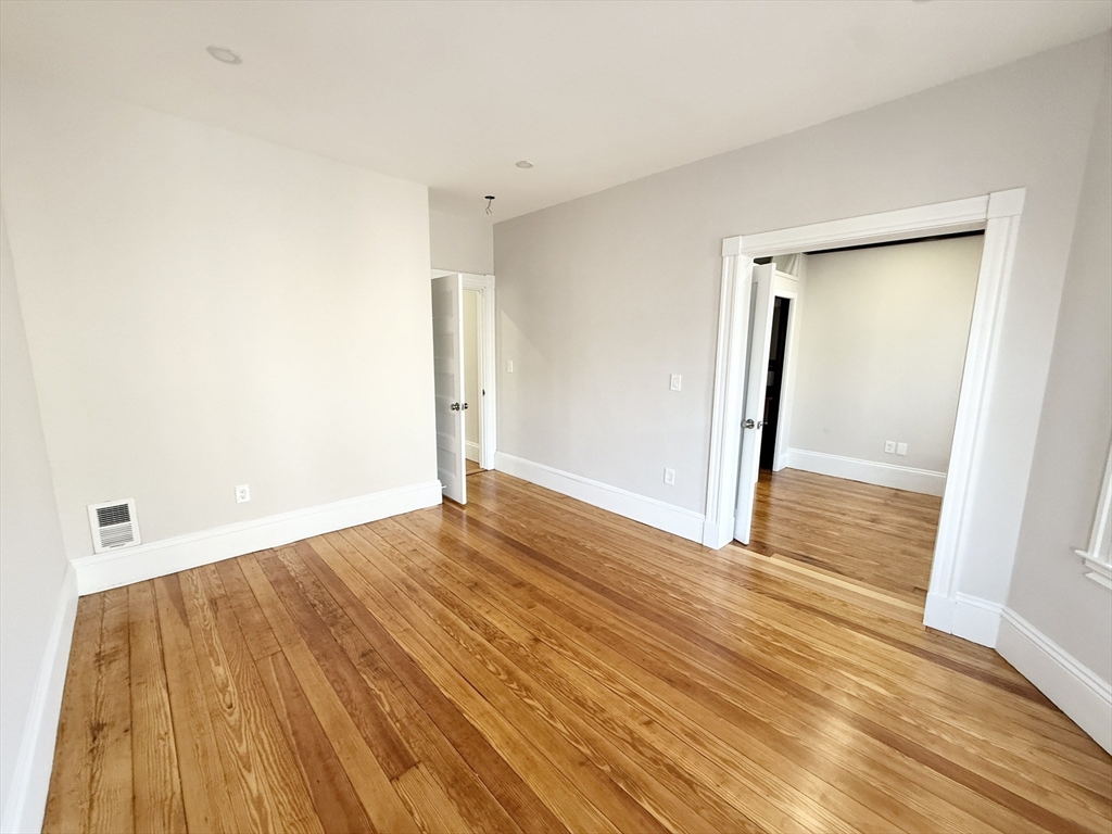 71 Saxton Street, Unit 2 Boston, MA 02125 - Photo 4 of 10 a view of an empty room with wooden floor