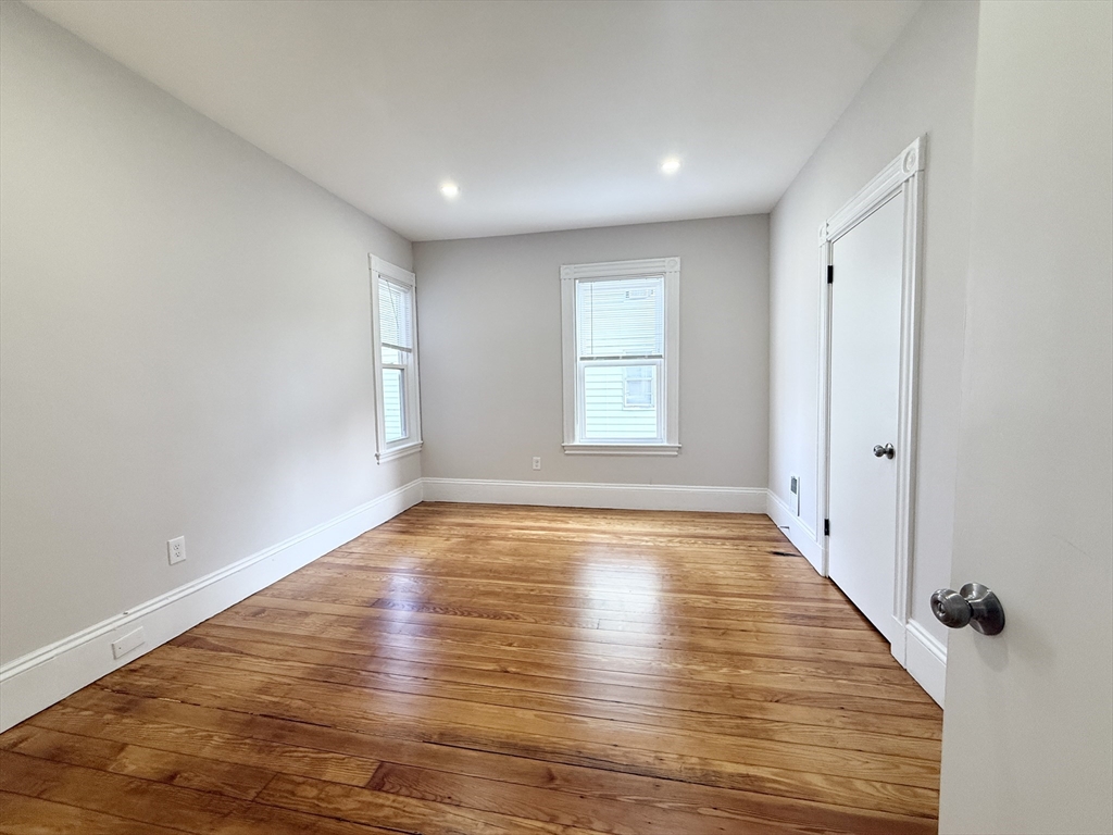 71 Saxton Street, Unit 2 Boston, MA 02125 - Photo 6 of 10 a view of an empty room with wooden floor and a window
