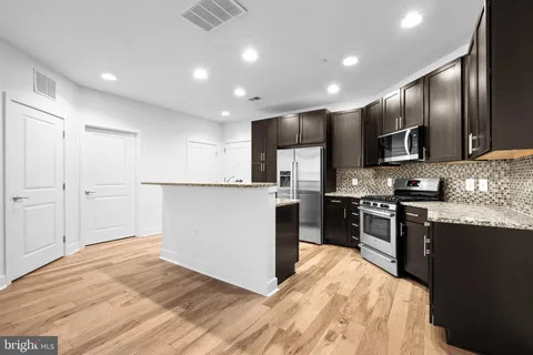 a kitchen with granite countertop stainless steel appliances and wooden cabinets