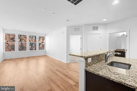 a kitchen with granite countertop a sink and a stove top oven