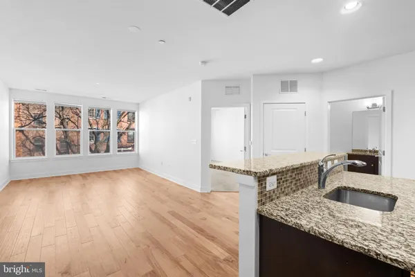 a kitchen with granite countertop a sink and a stove top oven