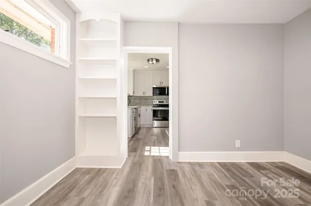 a view of a kitchen with wooden floor and a window