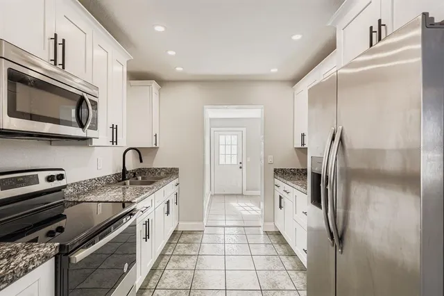 a kitchen with stainless steel appliances granite countertop a refrigerator and a stove top oven