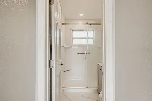 a bathroom with a shower and a glass door