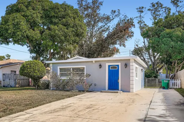 a front view of house with yard and trees in the background