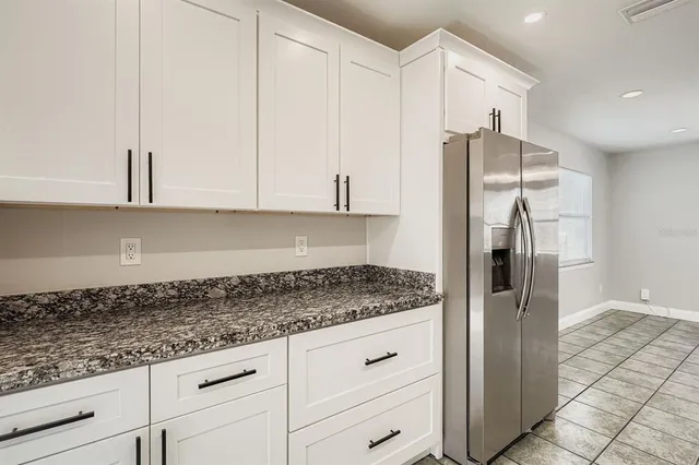 a kitchen with stainless steel appliances granite countertop white cabinets and a granite counter top