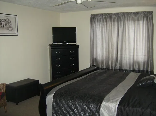 a bed sitting in a bedroom next to a window