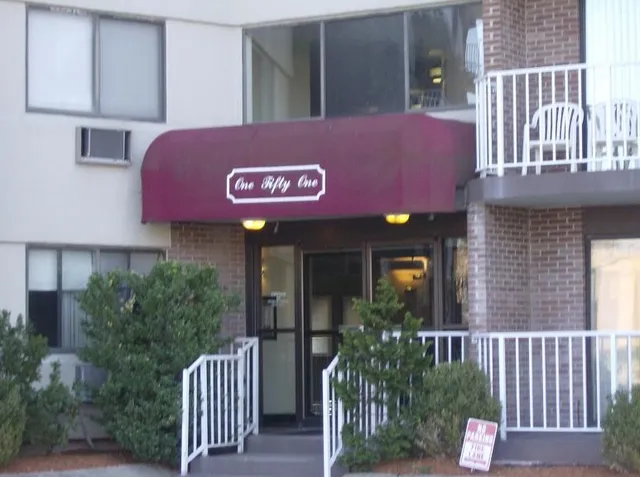 a view of a brick house with a small yard and plants