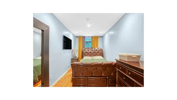 a living room with a bed furniture and a flat screen tv