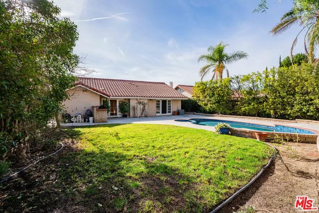 a view of a house with swimming pool and yard with green space