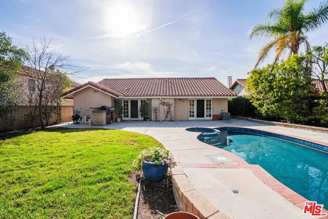 a view of a house with a yard and potted plants
