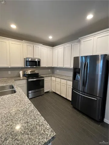 a kitchen with wooden cabinets and stainless steel appliances