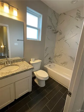 a bathroom with a granite countertop toilet a sink and bathtub