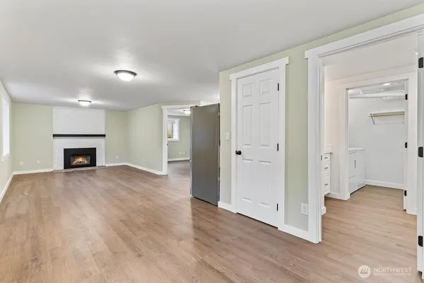 an empty room with wooden floor and fireplace