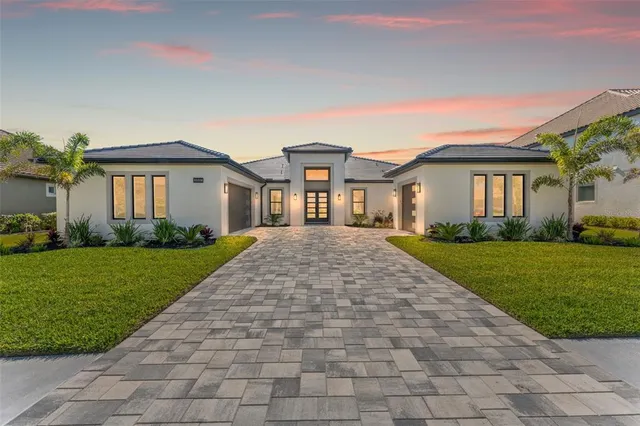 a front view of a house with a garden and yard