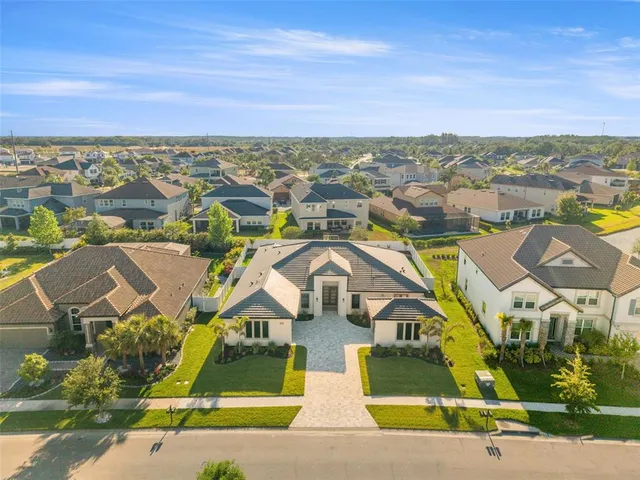 an aerial view of residential houses with outdoor space and ocean view