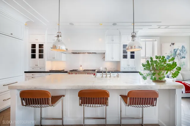 a bathroom with a sink a large mirror and a potted plant