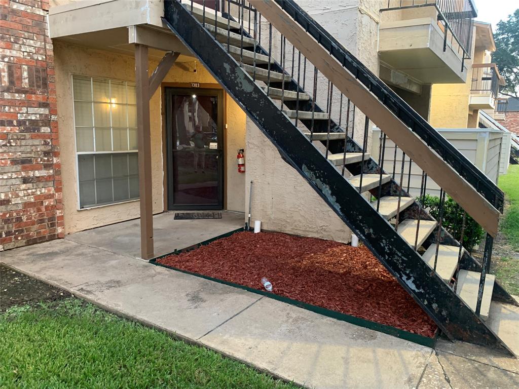 12482 Abrams Road, Unit 1303 Dallas, TX 75243 - Photo 4 of 30 Brick accent wall, covered entry, concrete pathway, decorative landscaping, exterior staircase
