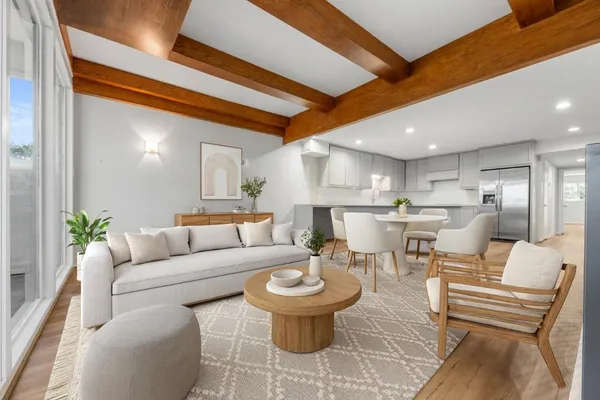 a living room with furniture and a dining table with kitchen view
