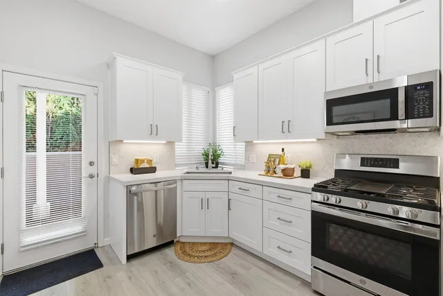 a kitchen with stainless steel appliances a refrigerator sink and microwave